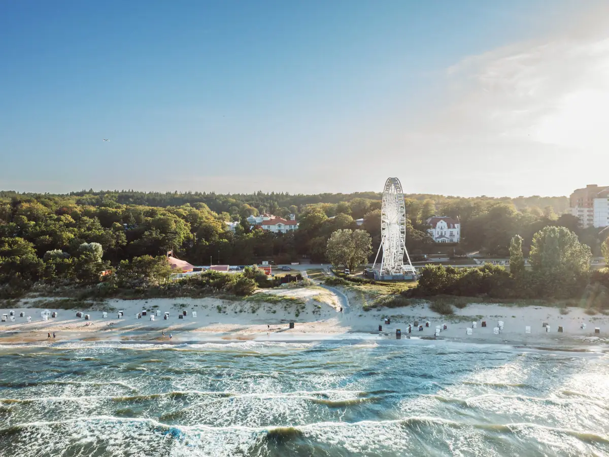 Strand mit Riesenrad und Bäumen im Hintergrund