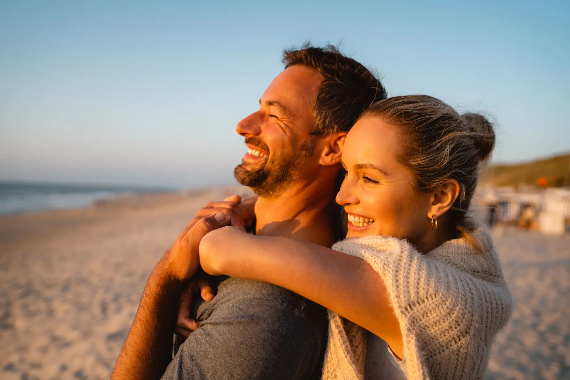 Ein Mann und eine Frau umarmen sich am Strand.