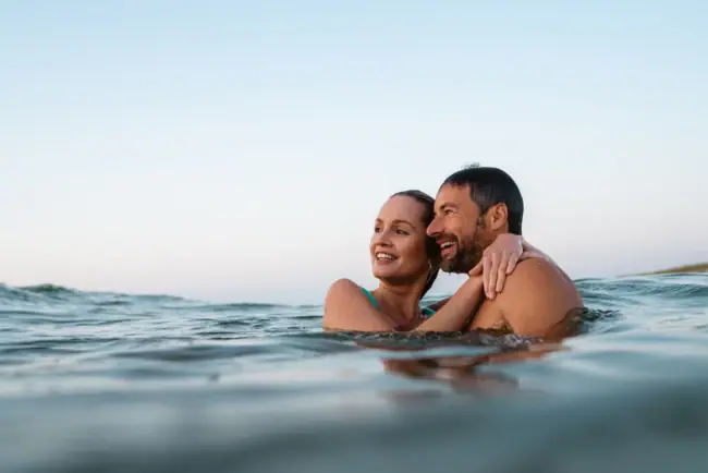 A-ROSA Sylt Baden Ein Mann und eine Frau im Wasser, lächelnd und glücklich.