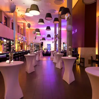 Eine große Bar mit Stehtischen und Stühlen in einem Hotel.