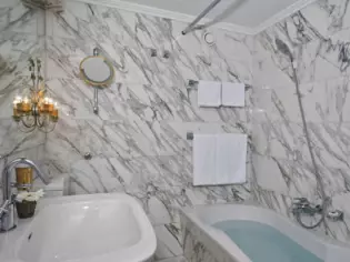 Ein luxuriöses Badezimmer aus Marmor mit einer Badewanne.