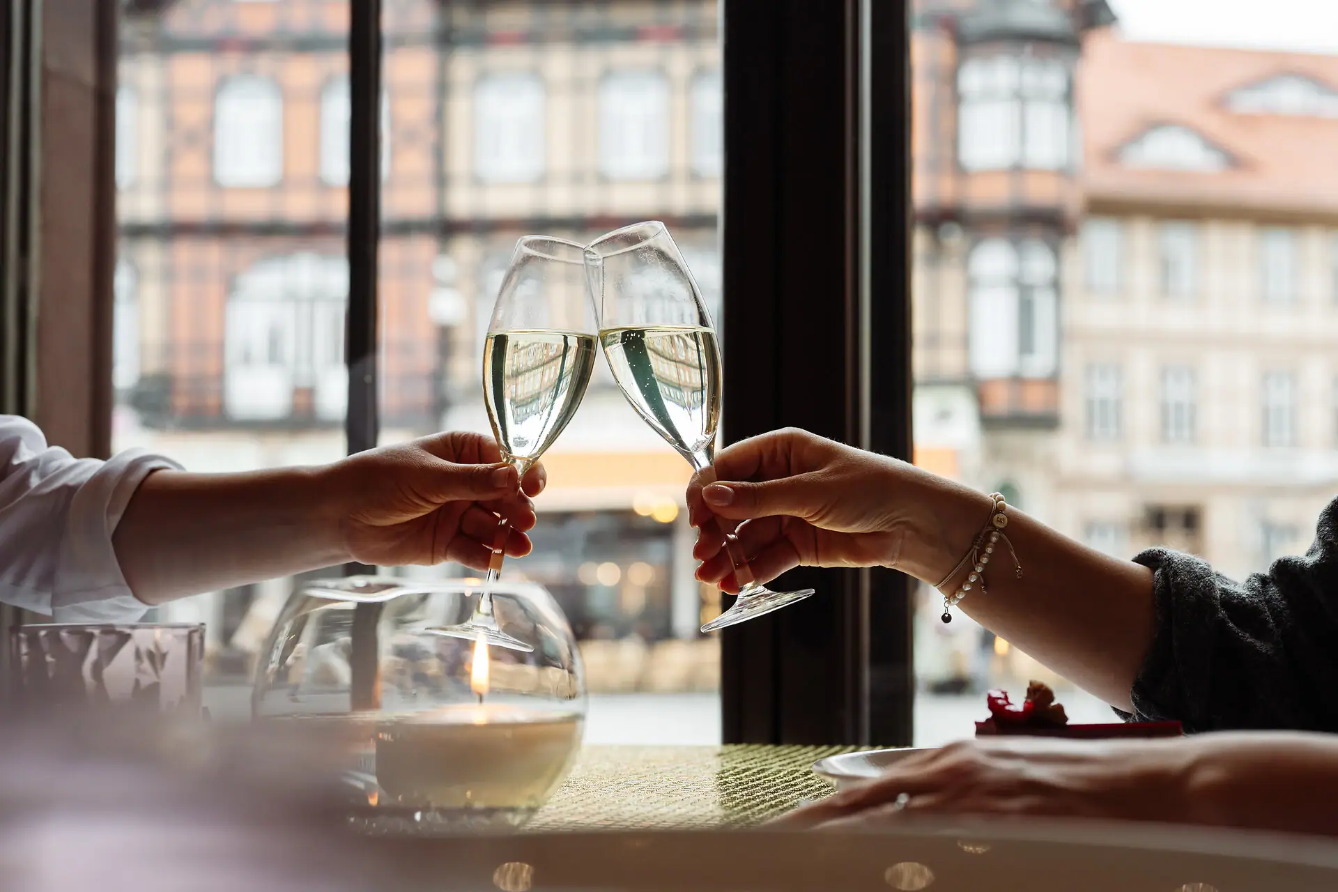 Zwei Hände stoßen mit Weingläsern an.