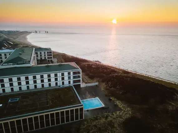 A-ROSA Sylt inmitten von Dünen und neben dem angrenzenden Meer. 