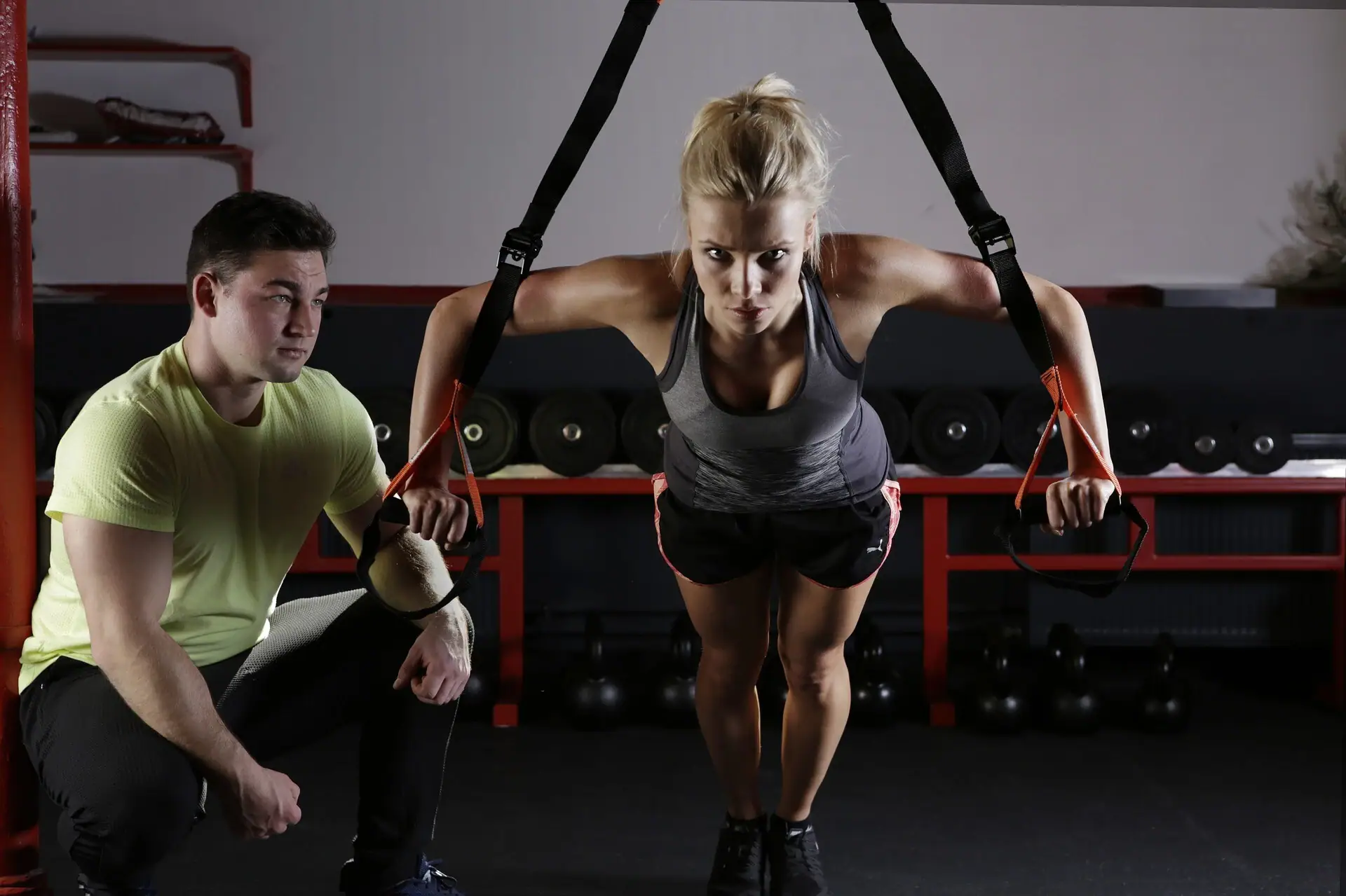 Eine Frau hebt ein TRX-Band in einem Fitnessstudio.