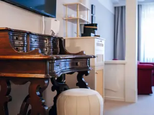 A wooden desk with a musical keyboard in a room.