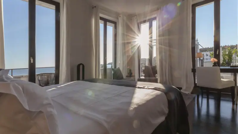 Ein Zimmer mit einem Bett und Fenstern.