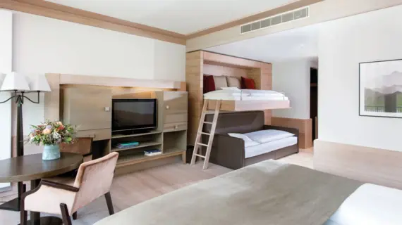 Interior view of a hotel room with a bed and a television.