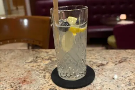 EIn Cocktailglas mit einem Strohhalm auf einem Tisch.