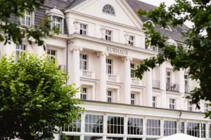 A-ROSA Travemünde Weißes Gebäude mit Bäumen im Hintergrund