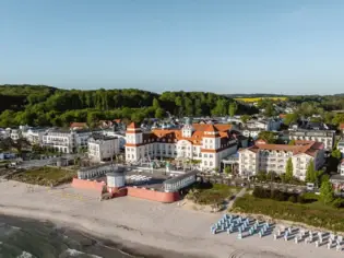 Strand mit großem Gebäude und Gewässer im Hintergrund