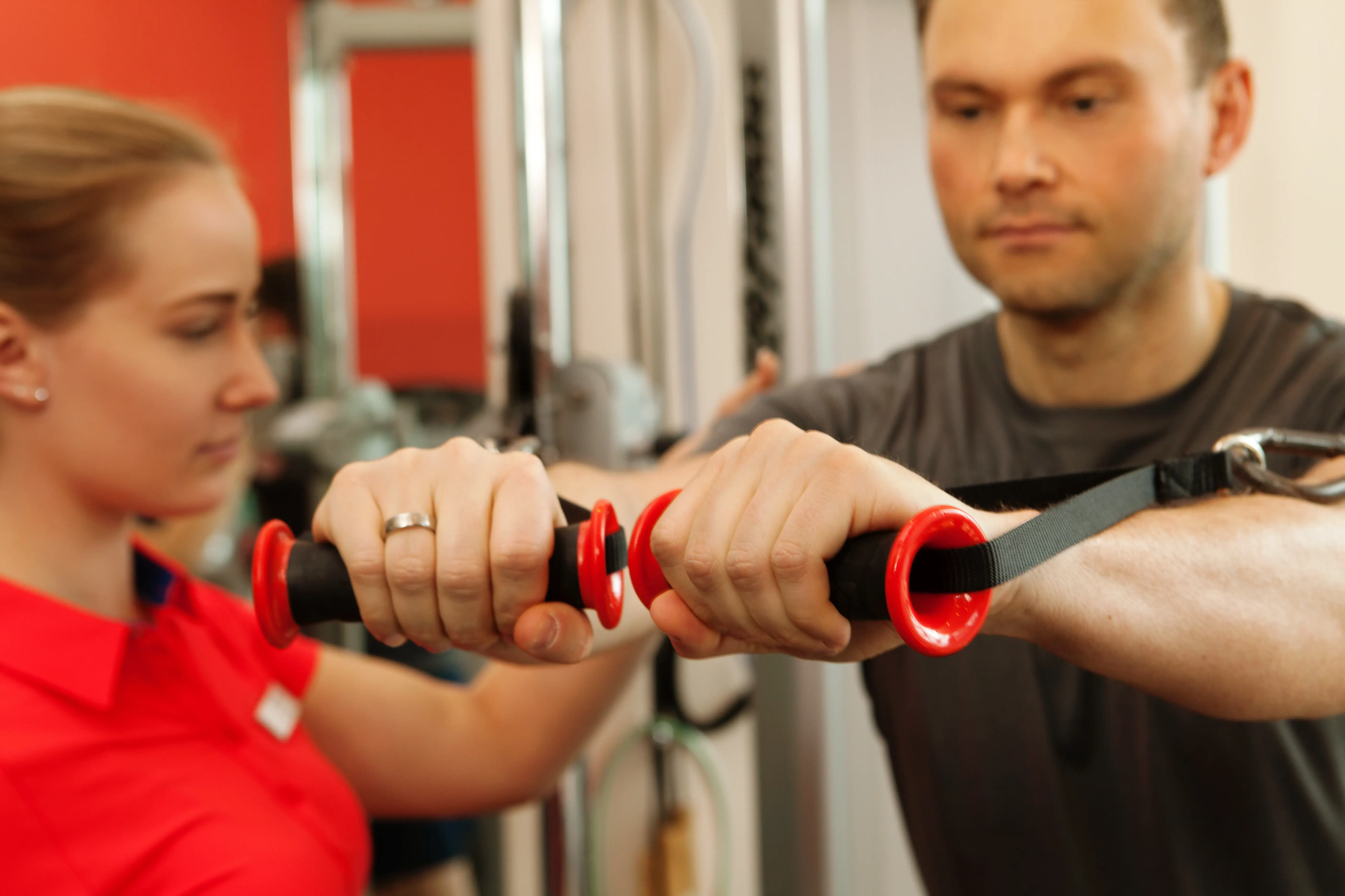 Ein Mann und eine Frau trainieren im Fitnessstudio.