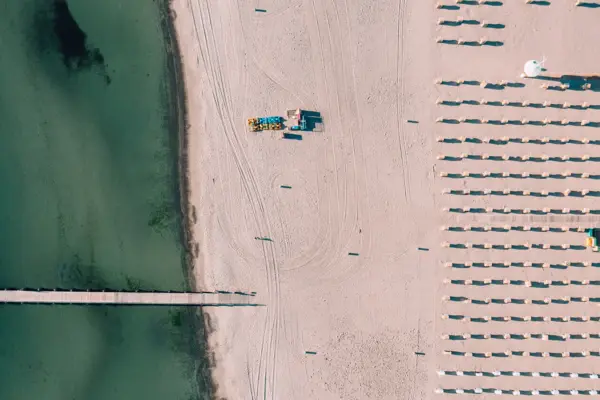 Strand mit Sonnenschirmen und einem Steg