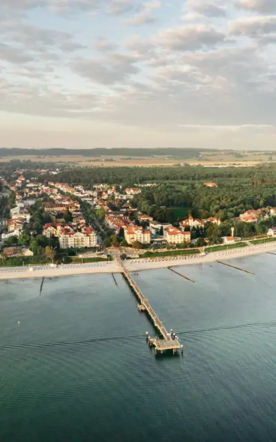 Eine Frau steht mit ihrem Goldequipment auf einem grünen Platz und schwingt den Schläger. 