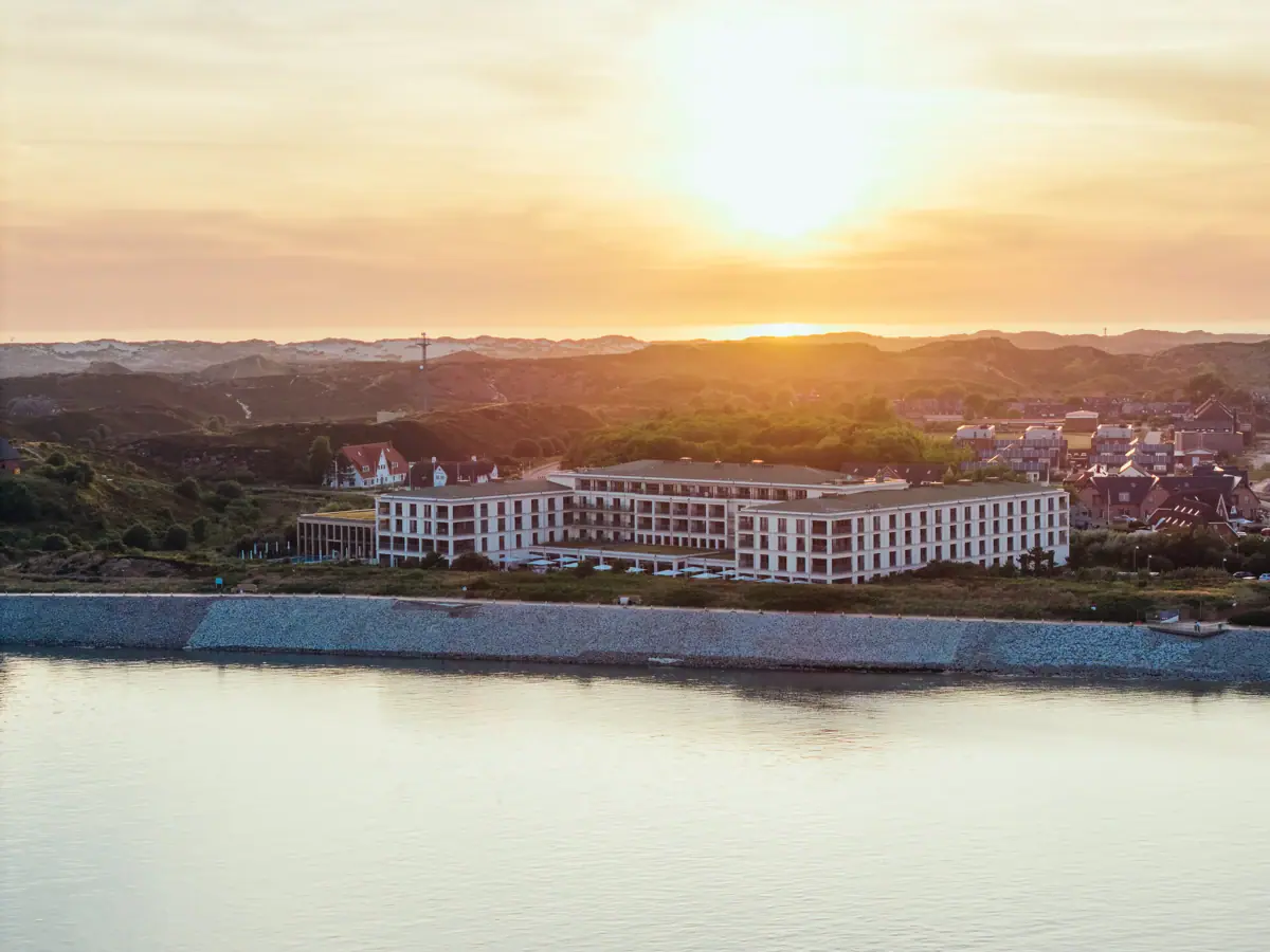 Ein Gebäude neben einem Gewässer im Freien bei Morgenhimmel.