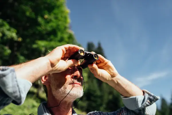 Ein Mann schaut durch ein Fernglas.