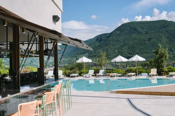 Ein Pool mit Liegestühlen und Sonnenschirmen neben einem Gebäude.