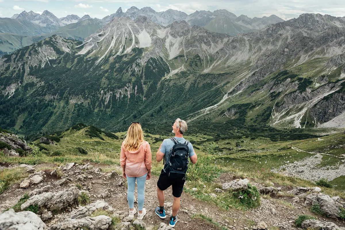 Ein Mann und eine Frau stehen auf einem Berggipfel.