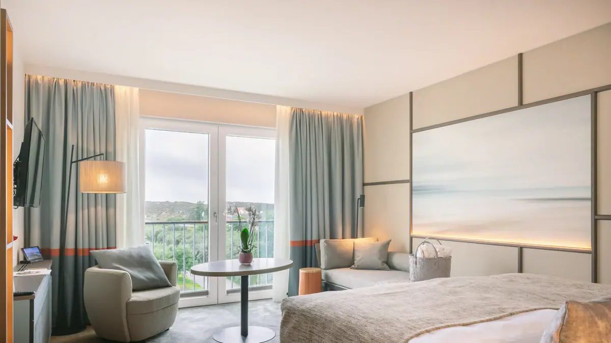 Ein Zimmer mit einem Bett und einem Tisch mit Stühlen.