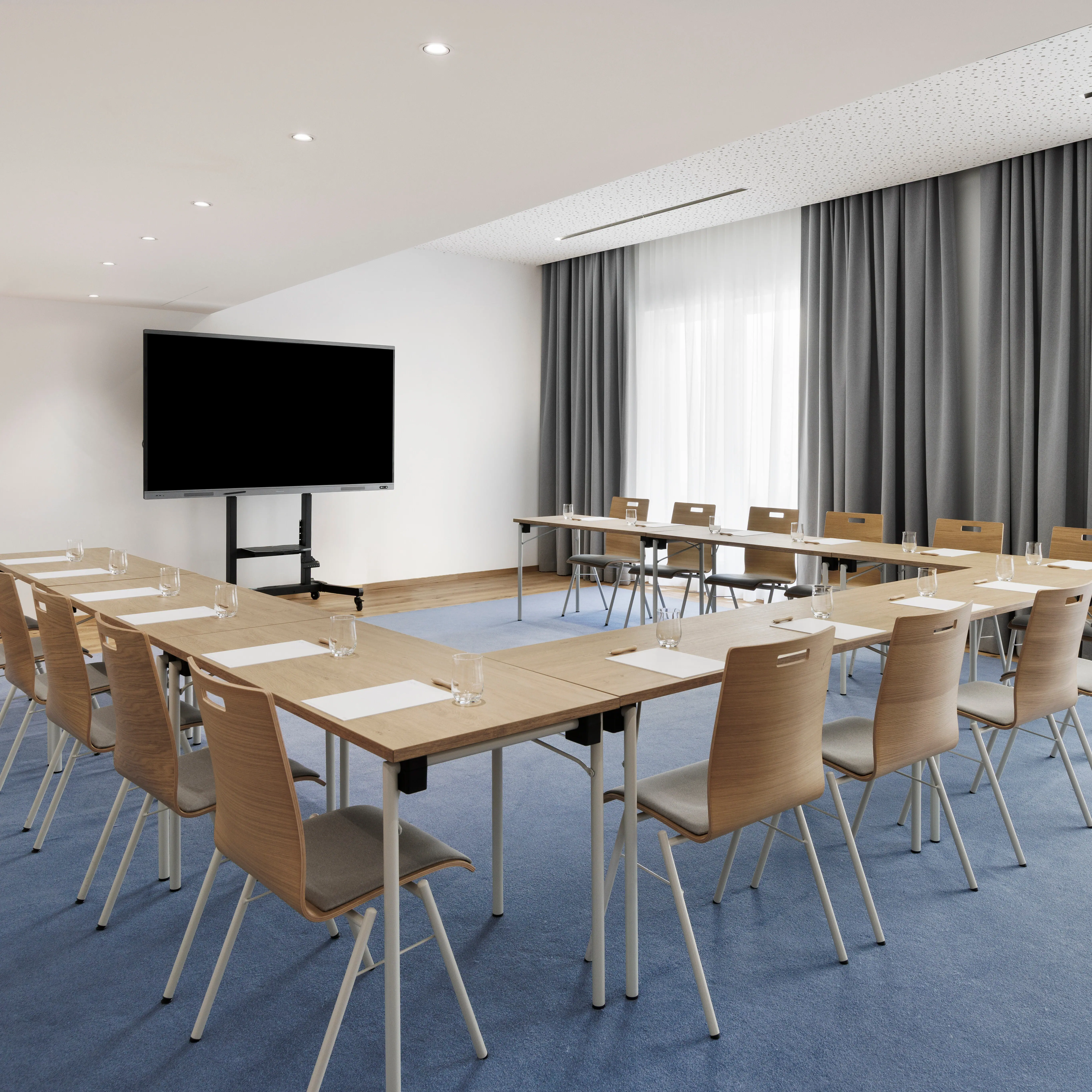 Ein Tagungsraum im A-ROSA Tegernsee mit einer Tafel im U-Form.