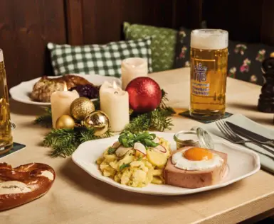 Ein appetitlich gedeckter Esstisch mit Süddeutschen Speisen und Bier.