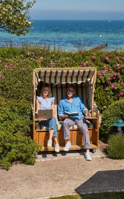 Ein Mann und eine Frau sitzen in einem Strandstuhl.