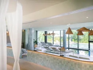 Ein Raum mit Liegestühlen und einem Pool.