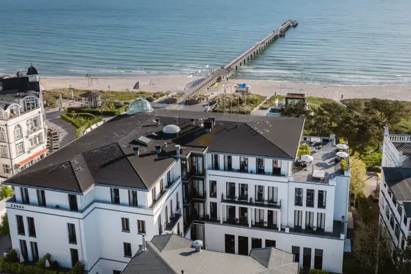 Strand mit einem Pier und Gebäuden im Hintergrund.