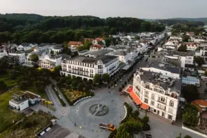 Vogelperspektive auf eine Stadt mit vielen Gebäuden und Bäumen.