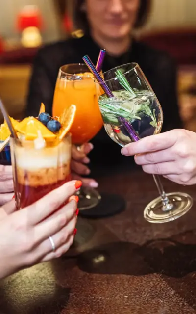 Eine Gruppe von Händen hält Cocktails.