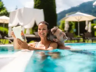 Ein Mann und eine Frau in einem Pool im Freien.