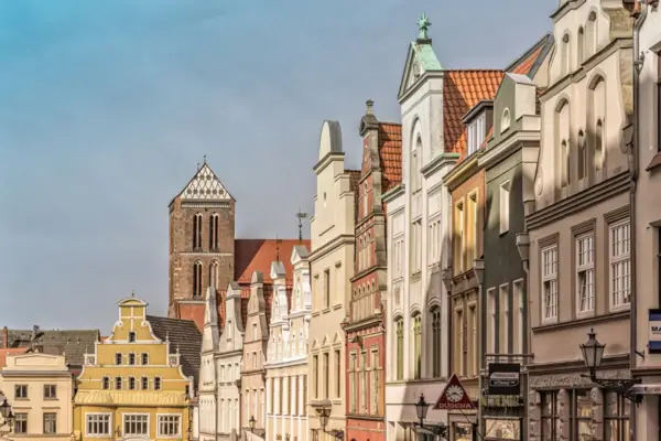 Eine Reihe von Gebäuden mit einem Kirchturm im Freien.