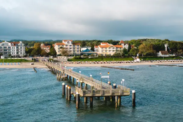 Steg am Wasser mit Himmel und Wolken im Hintergrund.